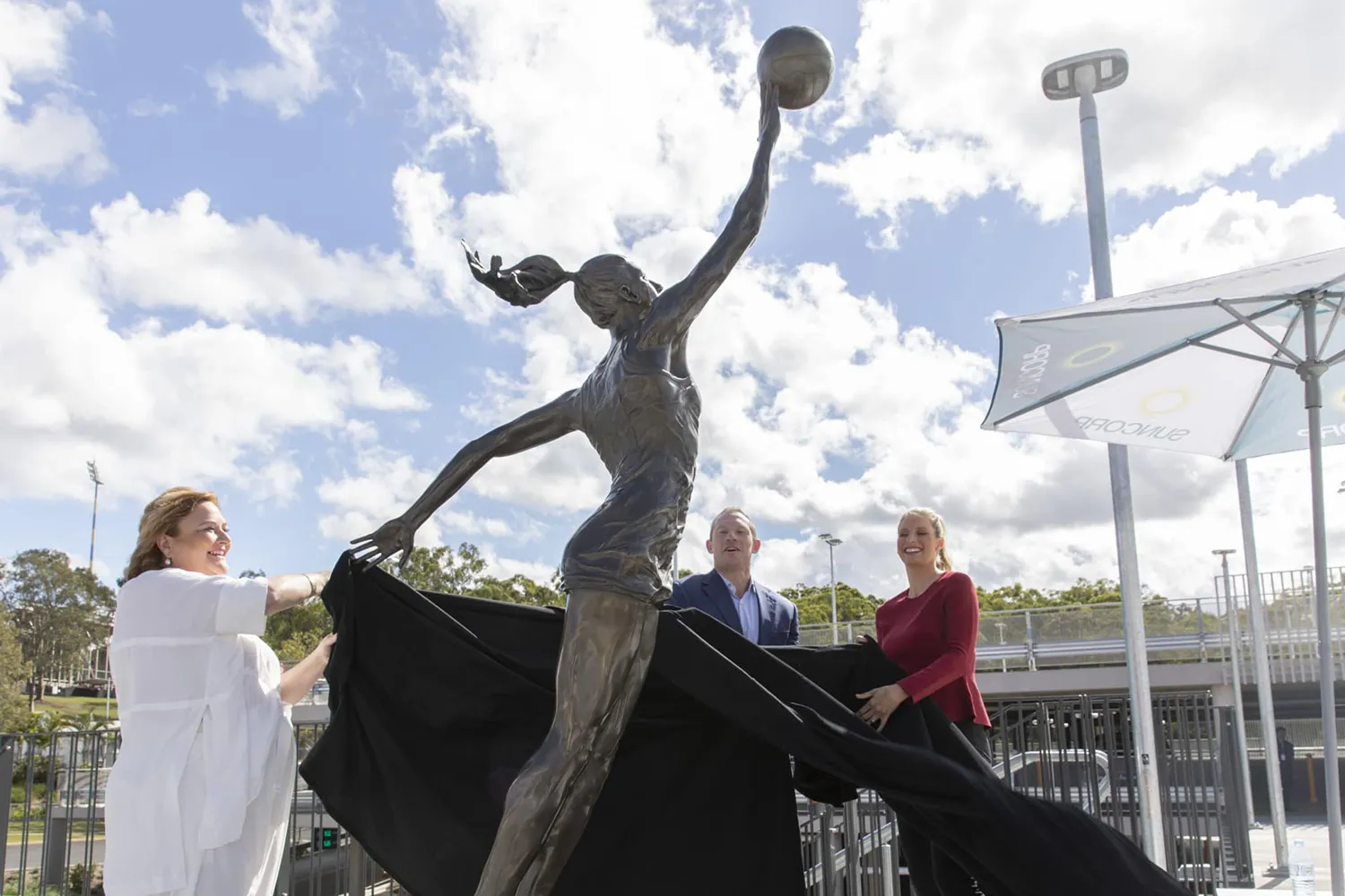 Laura Geitz's bronze statue being unveiled, with a proud backdrop of a clear sky