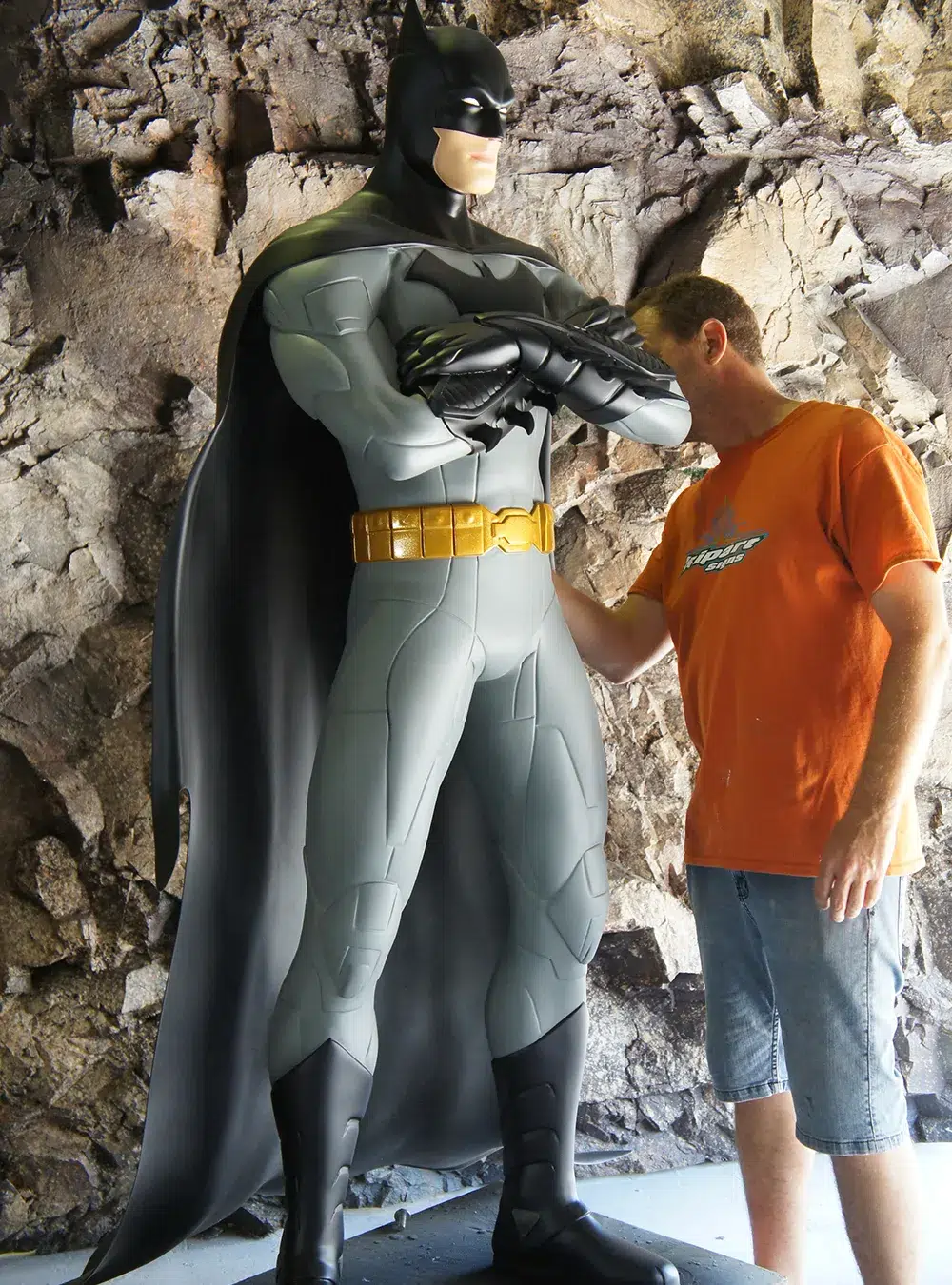 Batman: The Dark Knight stands tall and imposing in this representation. The sculpture captures Batman's stoic demeanor and vigilance, with a well-defined musculature and the iconic bat-symbol on his chest. The detailing on the suit, especially the texture and the folds, make it look realistic.